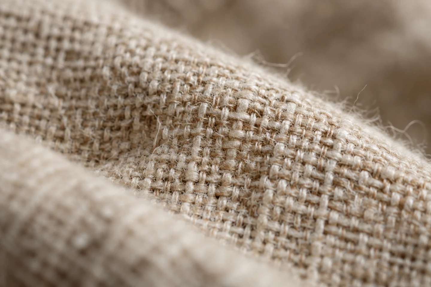 Gros plan sur le tissage d'un lin beige : fibres irrégulières et relief du tissu